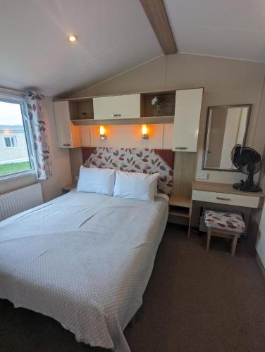 a bedroom with a large bed and a mirror at Hidden Gem Wilksworth Caravan Park Rural and Peaceful Setting in Wimborne Minster