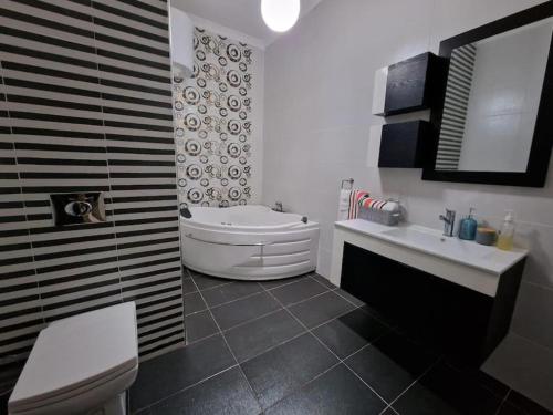 y baño con bañera, aseo y lavamanos. en MIVE -Bugibba Modern Apartment next to main square, en St Paul's Bay