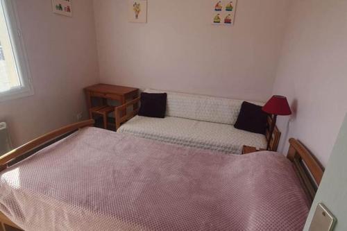 une petite chambre avec un lit et un canapé dans l'établissement Maison proche de la plage - 0971, à Vendays-Montalivet