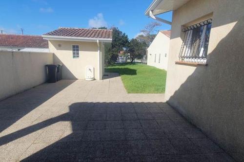 une ombre d'un bâtiment sur le côté du trottoir dans l'établissement Maison proche de la plage - 0971, à Vendays-Montalivet