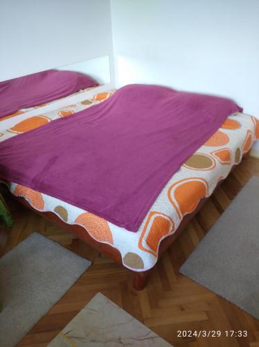 盧戈日的住宿－inchiriez 2 camere in apartament de 3 camere，一张带紫色和橙色棉被的床