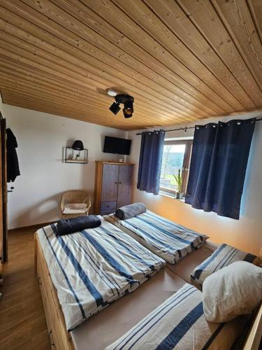 1 dormitorio con 2 camas y techo de madera en d' Aussicht nach LA, en Deggendorf