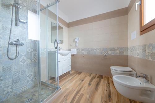 a bathroom with a shower and a toilet and a sink at Borgo Specchia Natural Resort in Specchia