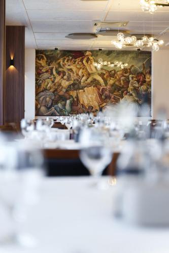 a painting on the wall in a restaurant with tables at Hotel Montana SPA in Kruševo