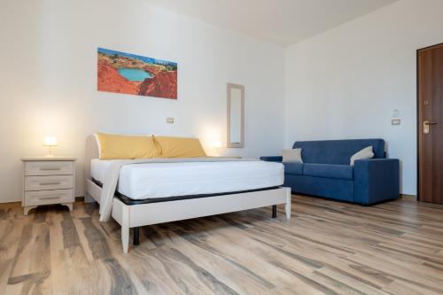 a bedroom with a bed and a blue couch at Borgo Specchia Natural Resort in Specchia