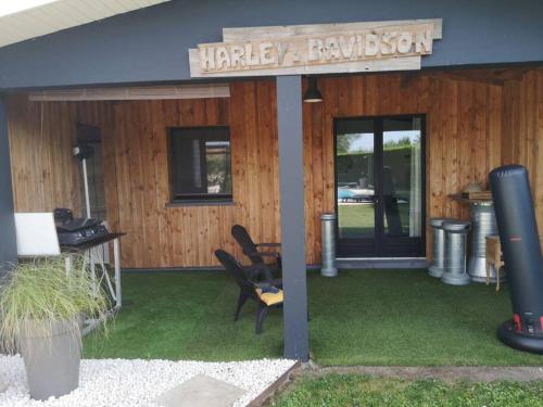 een huis met een bord waarop staat Harley David bij Studio style biker avec parking fermé in Izon