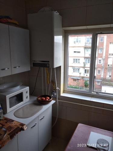 盧戈日的住宿－inchiriez 2 camere in apartament de 3 camere，带微波炉的小厨房和窗户。