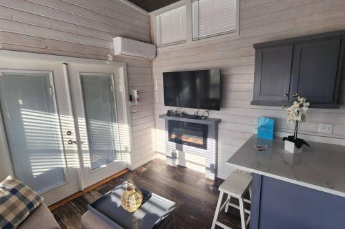 uma sala de estar com lareira e uma televisão de ecrã plano em Wheeler Lake Meadow Cabin 4 em Shelby