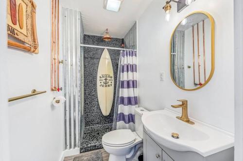 フォート・ウォルトン・ビーチにあるLivin Right Surf Loft: pickleball, basketball, close to the funのバスルーム(シンク、壁にサーフボード付)
