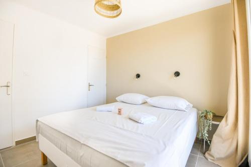 une chambre avec un lit blanc avec deux oreillers dans l'établissement Appart 3 ch neuf proche Saint-Charles Belle de Mai, à Marseille