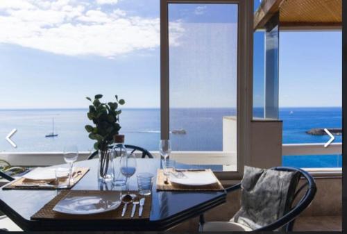a dining room table with a view of the ocean at Penthouse Urbanizacion Montemarina Anfi del Mar in Mogán