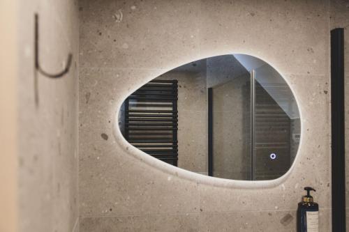 a circular mirror on a wall in a bathroom at Wood (Forestia) in Theux
