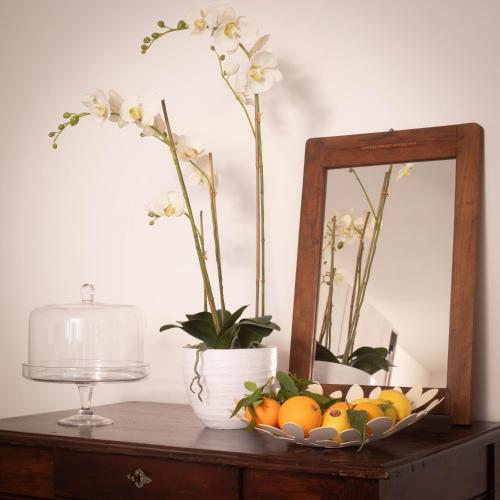 a table with a bowl of fruit and a mirror at Ai Priori in Gemona del Friuli