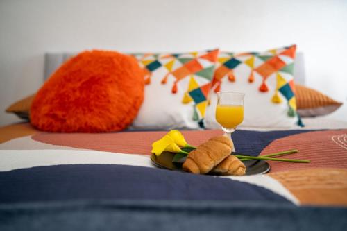 a plate of food and a glass of orange juice on a bed at Cosmopolitan Comforts Flat in Coventry