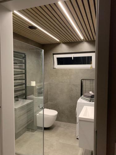 ein Bad mit einer Dusche, einem WC und einem Waschbecken in der Unterkunft Eksluzywny apartament w zaciszu in Kristiansund