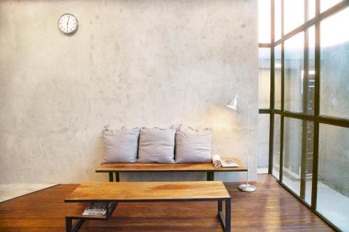a room with a bench with pillows and a clock at Flores Passport House in Ende