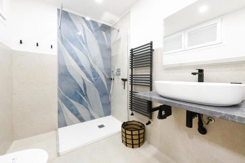 uma casa de banho com um lavatório e um chuveiro em MGH Family Stay - Costa DOro Superior Apartment em Sirmione