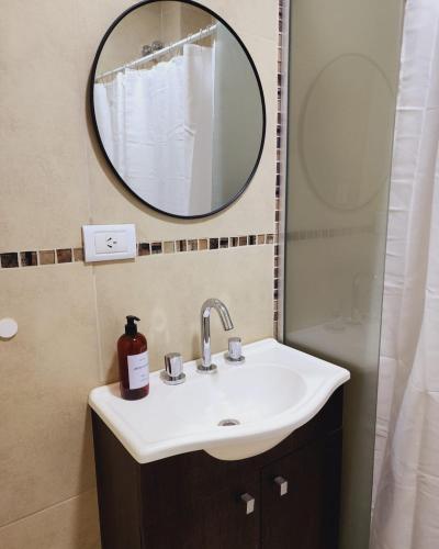 a bathroom with a sink and a mirror at Junidep - Alquiler Temporario - Deptos Nuevos! in Junín