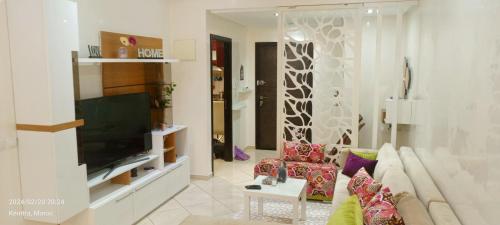 a living room with a couch and a flat screen tv at Luxury Appartement, en plein centre in Kenitra