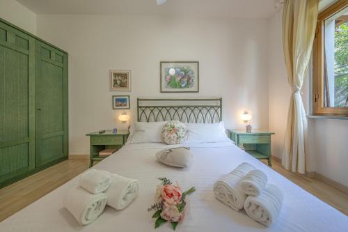 een slaapkamer met een wit bed met handdoeken en bloemen erop bij CASA ISABELLA Relax con Piscina in Rapallo