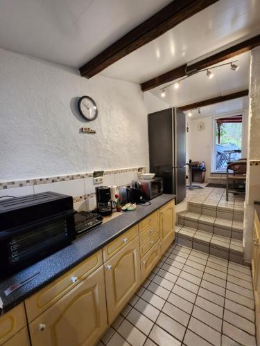 a kitchen with a counter and a clock on the wall at Gästehaus Beurener Mühle in Bad Bertrich