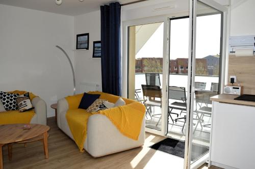 - un salon avec un canapé et une table avec un balcon dans l'établissement Entre Plage et Ports, Le 49 - avec balcon 4 étoiles, à Courseulles-sur-Mer