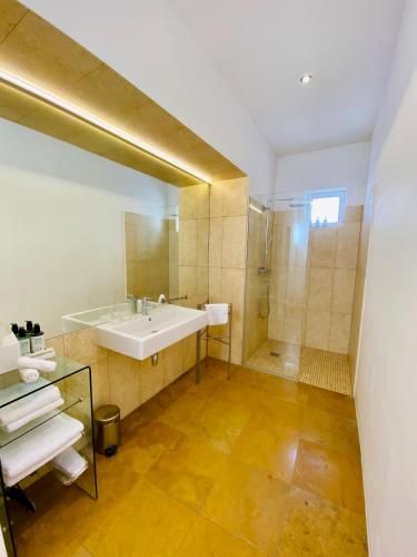 a bathroom with a tub and a sink and a shower at Gut Purbach in Purbach am Neusiedlersee