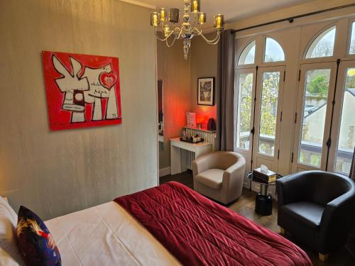 a bedroom with a bed and a desk and a chair at Le Castel Guesthouse in Bayeux