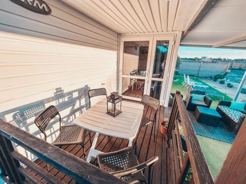 a porch with a wooden table and chairs on a balcony at Palmaradise in El Palmar
