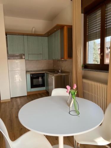 a white table with a vase with a flower on it at La casa di Amalia in Rho