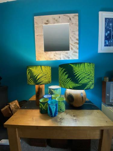 stół z dwoma lampami i niebieską ścianą w obiekcie Shaptor Studio w mieście Bovey Tracey