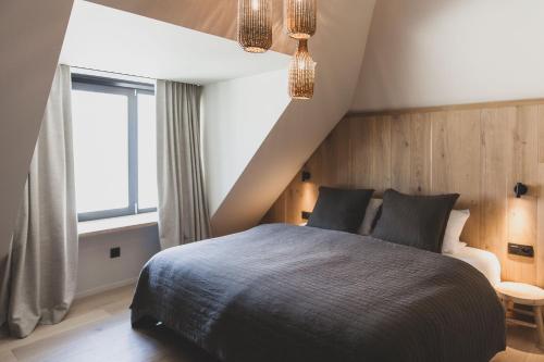 a bedroom with a large bed and a window at Wood (Forestia) in Theux