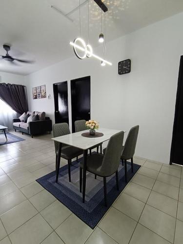 a dining table and chairs in a living room at Cozy Nest at Coutryhomes Rawang by Bliss Stay Management in Rawang