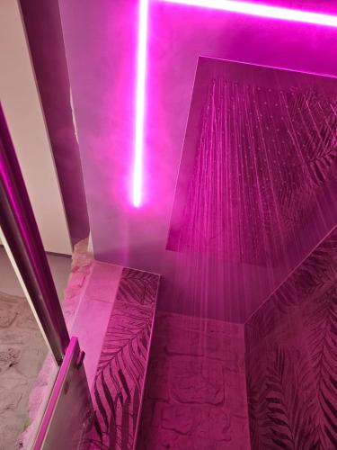a room with purple lights on the ceiling at LUXUITE Spa con Piscina o Jacuzzi in Alberobello