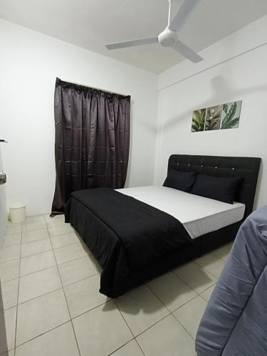 a bedroom with a black bed and a window at Cozy Nest at Coutryhomes Rawang by Bliss Stay Management in Rawang