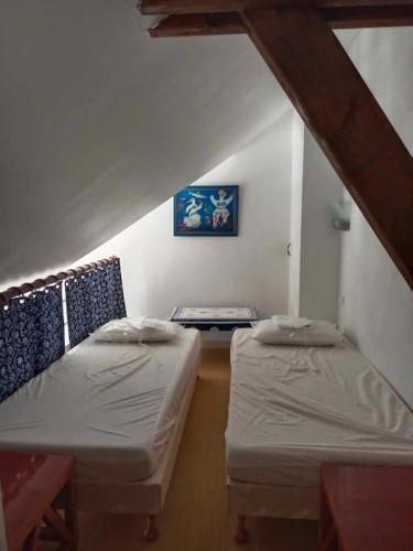 une chambre mansardée avec deux lits et une table dans l'établissement L'envol du Goéland, au Croisic