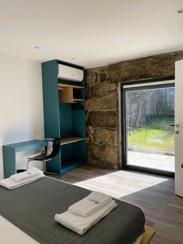 a bedroom with a blue desk and a window at Hotel Quinta da Tulha By VimaHotels in Guimarães