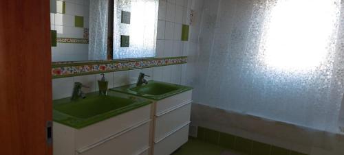 a bathroom with two green sinks and a mirror at AL "Villa Por Do Sol" Sunset Olhão in Olhão