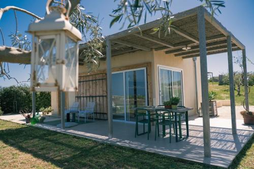 a house with a patio with a table and chairs at NEW Exclusive Lodges, Marzamemi, Noto in Pachino
