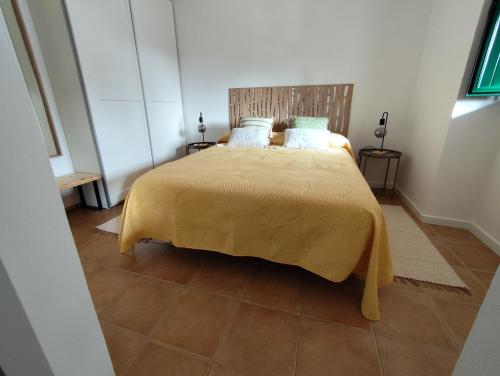 1 dormitorio con 1 cama con colcha amarilla en Vila Nova Guest House en Mértola