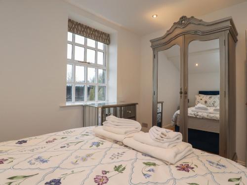 um quarto com uma cama e um espelho grande em The Lodge House em Lancaster