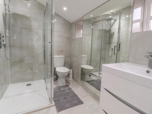 a bathroom with a shower and a toilet and a sink at The Lodge House in Lancaster