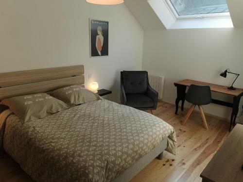 um quarto com uma cama, uma secretária e uma cadeira em Appartement à Valognes : Entre Terre et Mer em Valognes