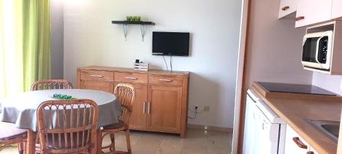 a small kitchen with a table and a tv on a counter at Apartamento Punta Montgo Port de Rei in L'Escala