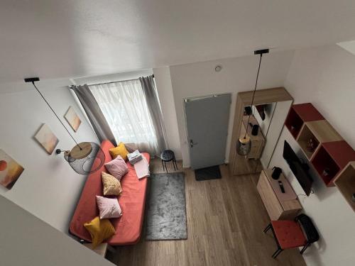 uma sala de estar com um sofá vermelho e uma guitarra em Oasis em Corbeil-Essonnes
