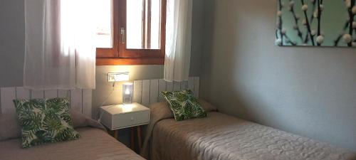 a small bedroom with two beds and a window at Apartamento Punta Montgo Port de Rei in L'Escala