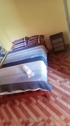 Una cama con una toalla en un dormitorio en Hospedaje PARAISO, en Ayacucho