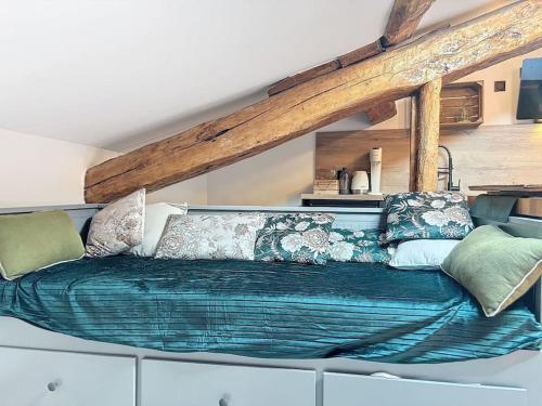 ein Zimmer mit einem großen Bett mit Kissen darauf in der Unterkunft Le sanctuaire des sorciers in Calmont