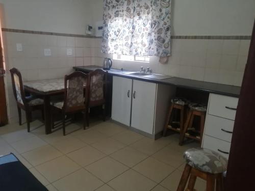 a kitchen with a sink and a table and chairs at GLORIA'S GUESTS.COM in Polokwane