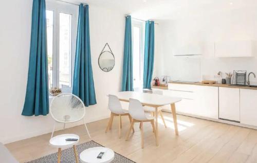une cuisine avec une table, des chaises et des rideaux bleus dans l'établissement AMAZING LARGE 1-BEDROOM, à Cannes
